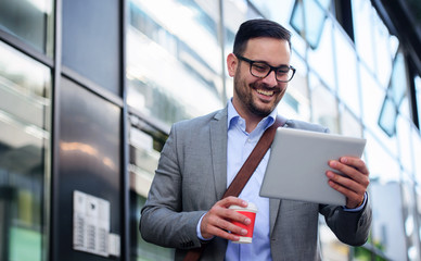 Fototapeta premium Businessman drinking coffee and checking notes with tablet. Business, lifestyle concept