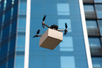 Drone delivering brown post package into urban city