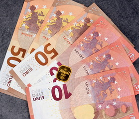 Gefächert liegende Euro-Banknoten mit einem Minigoldbarren