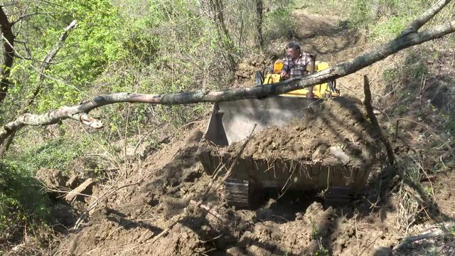 Operatore forestale apre pista con un pala cingolata