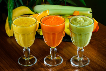 Orange, green, red colored smoothies freshly squeezed juice
