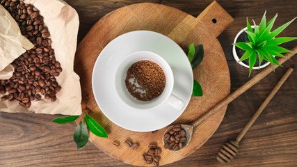 Coffee cup and coffee beans on wooden board. Top view.