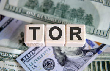 Fototapeta premium TOR financial business concept. Wooden cubes and paper dollar bills as a background