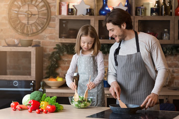 Loving father teaching little girl how to cook healthy food