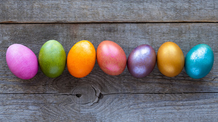 Beautiful multi-colored Easter eggs lie on a old wooden background, Easter holiday, copy space