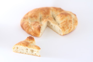 Slices of Ramadan Pita (Ramazan Pidesi) Traditional Turkish bread for holy month Ramadan on white background. Ramadan concept.