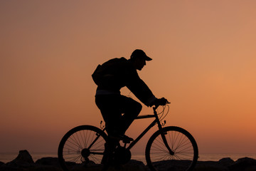 silhouette of man riding bicycle