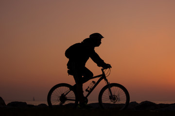 silhouette of man riding bicycle