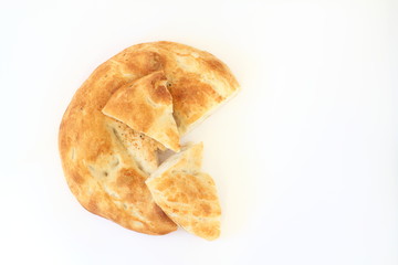 Slices of Ramadan Pita (Ramazan Pidesi) Traditional Turkish bread for holy month Ramadan on white background. Ramadan concept.
