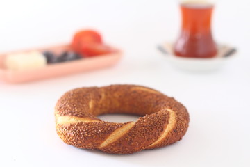 Turkish bagel, simit, tomatoes & Turkish tea on white background. 
