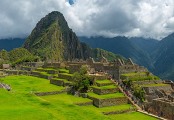 Main Square of Machu Picchu Ruin with agriculture fields and tourists along the walking path, Cusco...