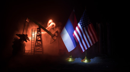 Business dialogue, oil agreement concept: National flags with Oil pump and oil refining factory at night with fog and backlight. Energy industrial concept.