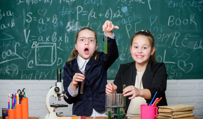 Be careful performing chemical reaction. Basic knowledge of chemistry. Girls study chemistry. Make studying chemistry interesting. Microscope and test tubes on table. Educational experiment concept