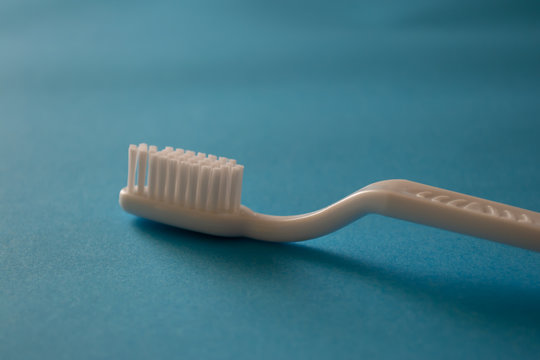 Close Up Plastic White Tooth Brush On Blue Background Dental Hygiene