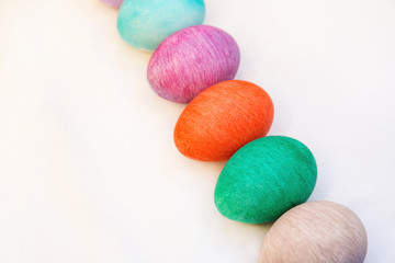 Flat lay easter composition with colorful eggs on a white background