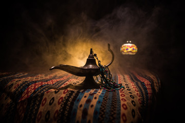 Lamp of wishes concept. Antique Aladdin arabian nights genie style oil lamp with soft light white...