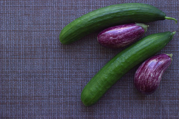 
Vegetable flatlay of graffiti zucchini and long smooth cucumbers on a brown mesh napkin