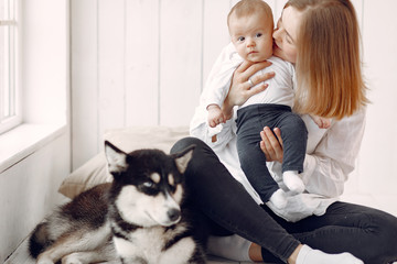 Beautiful woman with child. Woman in a white shirt. Family playing with big dog.