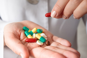 Medicine pills or capsules in hand, palm or fingers.
