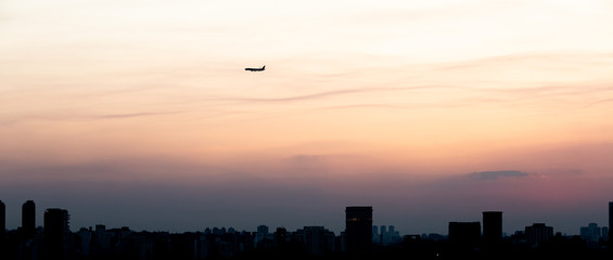 Airplane getting ready to land in Sao Paulo during a beautiful sunset.