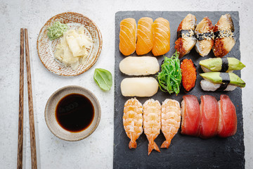 Set of sushi and maki with soy sauce over white background. Top view with copy space