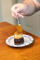 adding caramel sauce to chocolate cake slice