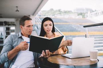 Concentrated freelancers working outdoors discussing problems