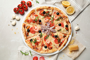 Tasty pizza with seafood and ingredients on light grey marble table, flat lay