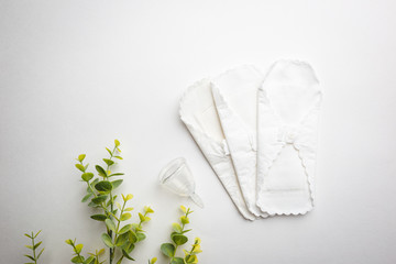 Fototapeta na wymiar Different types of feminine hygiene products-menstrual cups, sanitary reusable pads on white background. Zero waste concept of menstruation.