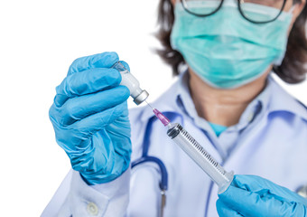 Close up syringe vaccine in hand physician while wearing surgical hygienic face mask for protection outbreak spreading coronavirus 