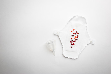Different types of feminine hygiene products-menstrual cups, sanitary reusable pads on white background. Zero waste concept of menstruation.