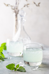 glass of cold drink with fresh mint leaves and ice cubes