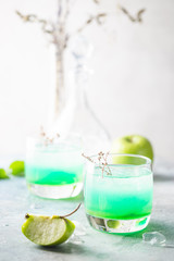 Green cocktail with apples on white background, martini cocktail in glasses