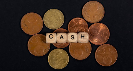 Cubes with the word CASH are on coins, concept