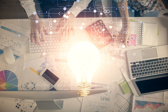 Double exposure of man and woman working together and bulb drawing. Computer background. Top View. Idea concept.