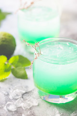 glass of cold drink with fresh mint leaves and ice cubes