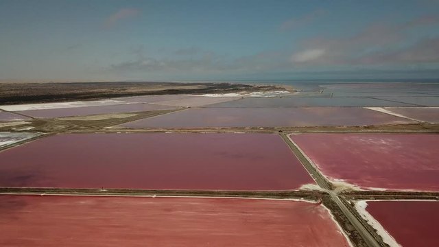 4K aerial drone video of salt works factory wide pink salty water evaporation ponds, in outskirts of coastal harbour town Walvis Bay, Namib Desert, Atlantic Ocean west coast, Namibia, southern Africa