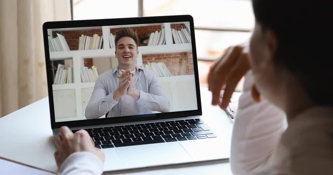 Male online teacher or coach videoconferencing training remote student by webcam teaching web lesson gives workshop during virtual computer chat conference video call. Over shoulder laptop screen view