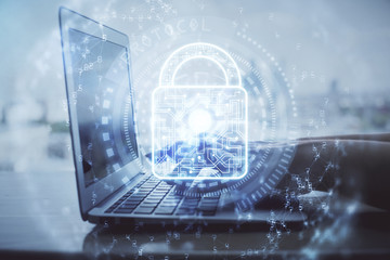 Double exposure of woman hands working on computer and lock hologram drawing. Security concept.