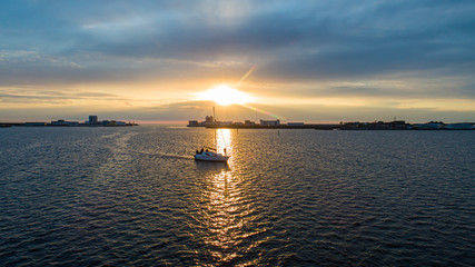 Boat at sunset on the background of the road through the dam in the Gulf of Finland