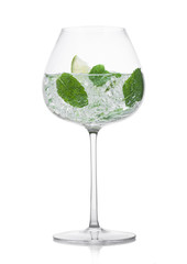 Glass of fresh sparkling water lemonade with mint and ice cubes and lime slice on white background.