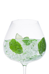 Glass of fresh sparkling water lemonade with mint and ice cubes on white background. Macro