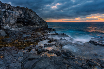 Obraz premium sea sunset at volcanic stones beach