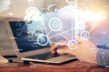 Double exposure of man's hands holding and using a phone and social network theme drawing.
