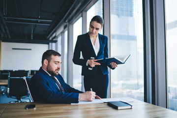 Formal female employee with executive in office in company