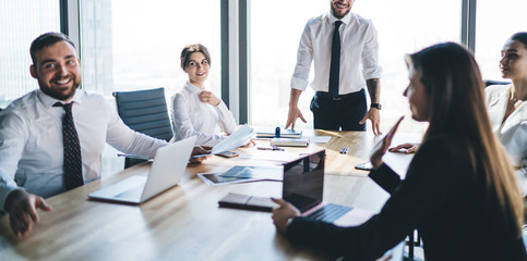 Colleagues with laptops sitting around table