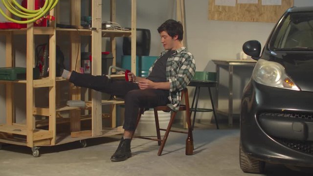 The guy smokes and fools around with tools in the garage