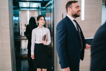 Confident businesswoman leaving elevator