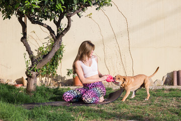 Young woman playing with her dog in garden - 337863500