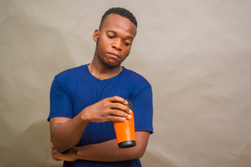 young handsome african man feeling happy as he holds a coffee cup